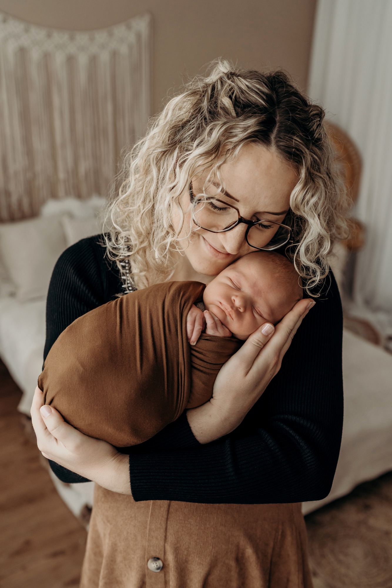 Mama kuschelt mit ihrem schlafenden Neugeborenen
