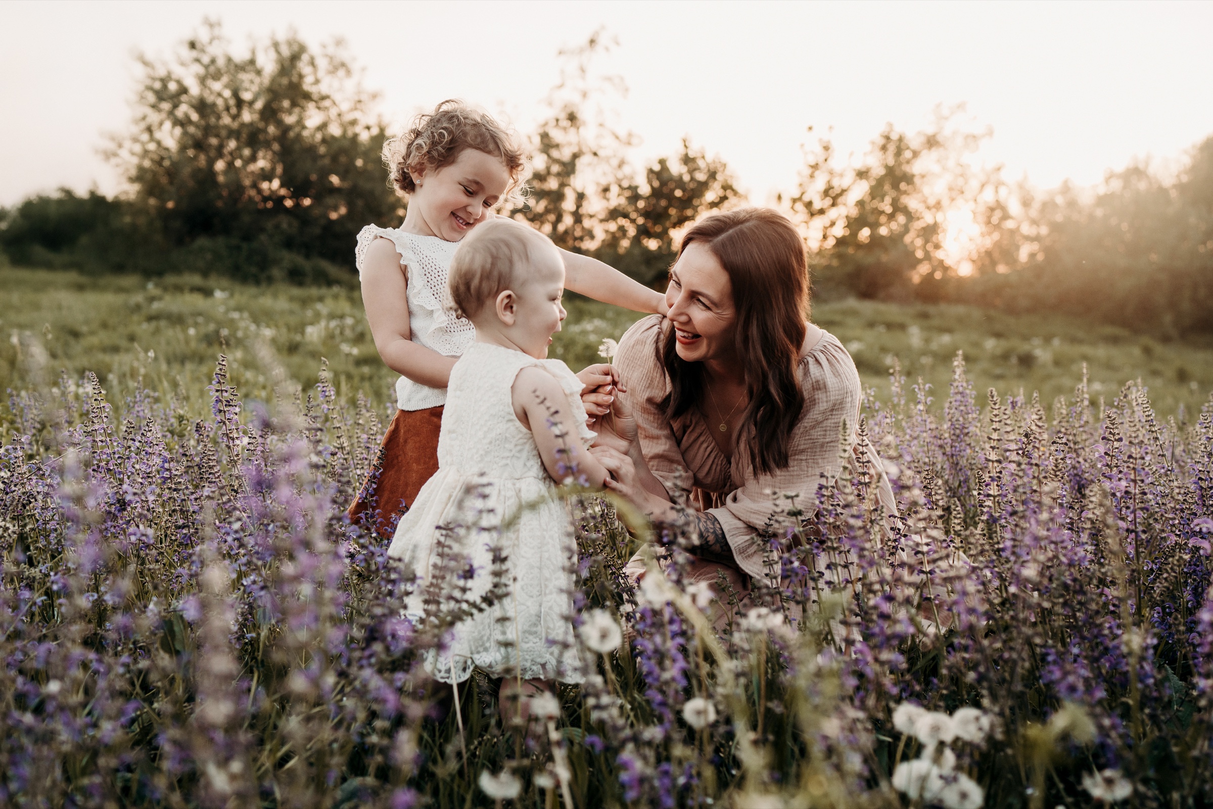 Mutter mit ihren beiden Kindern in einer Blumenwiese